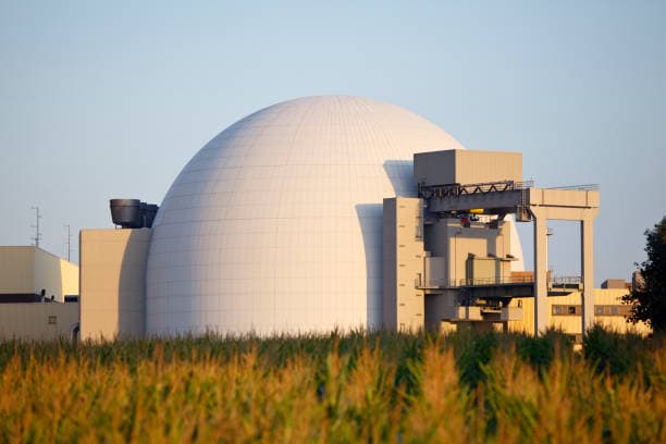 Nuclear power plant containment dome behind a field of crops